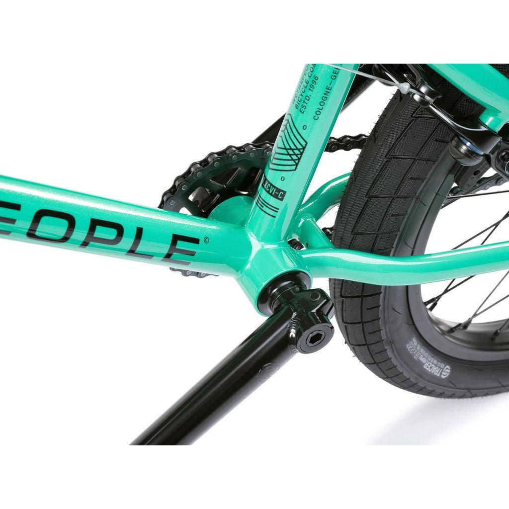 Close-up of a Wethepeople CRS FS 18 Inch BMX bike in turquoise, showcasing the frame, crankset, chain, and rear tire against a white background.