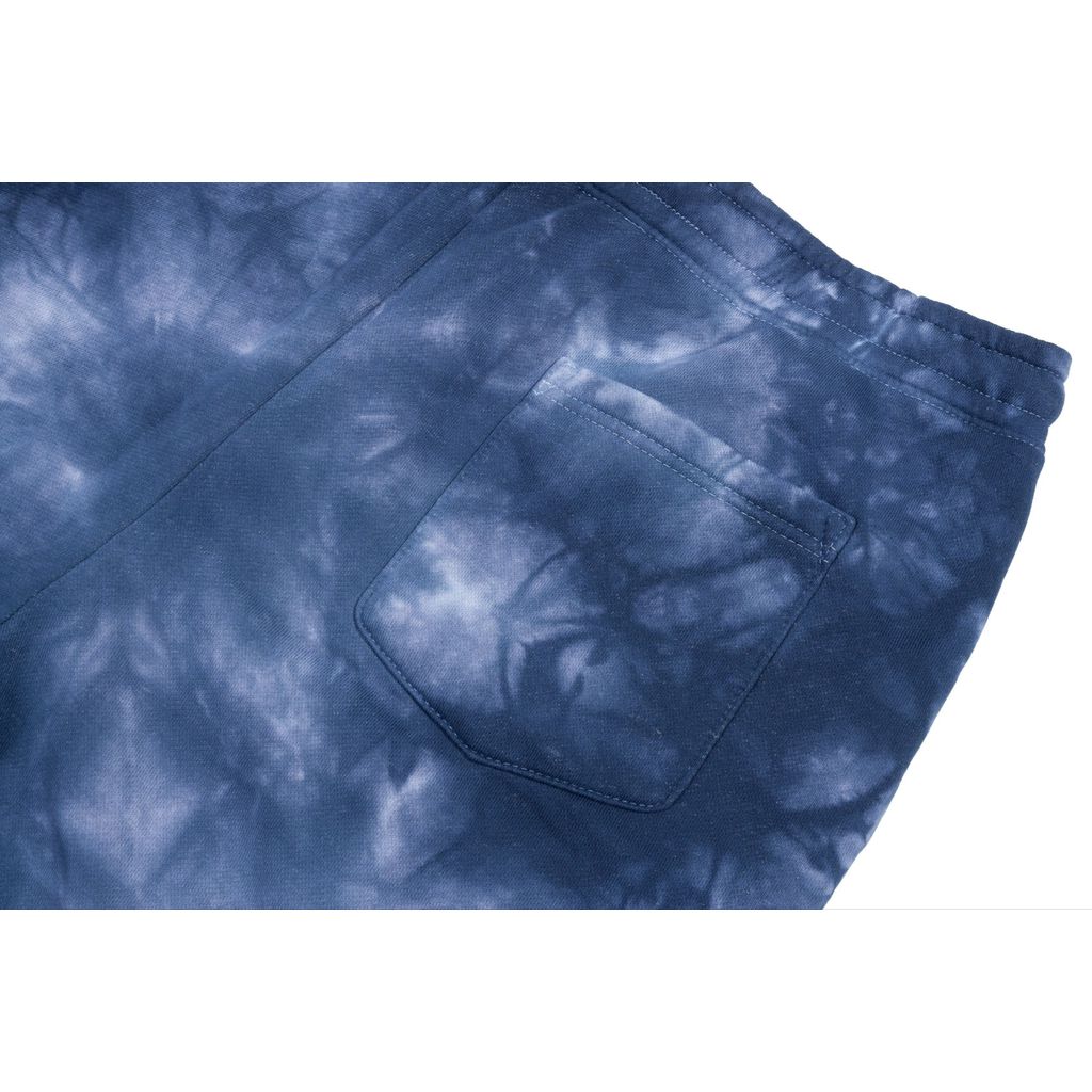 A close-up of the back pocket on blue tie-dye Sunday Cornerstone Sweat Shorts with an elastic waistband, perfect for any size; be sure to check our size guide for the best fit.