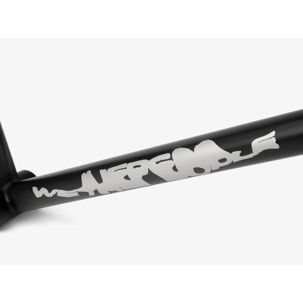 Close-up of a Wethepeople Tomorrow Frame, featuring graffiti-style writing in white on its sleek black surface.