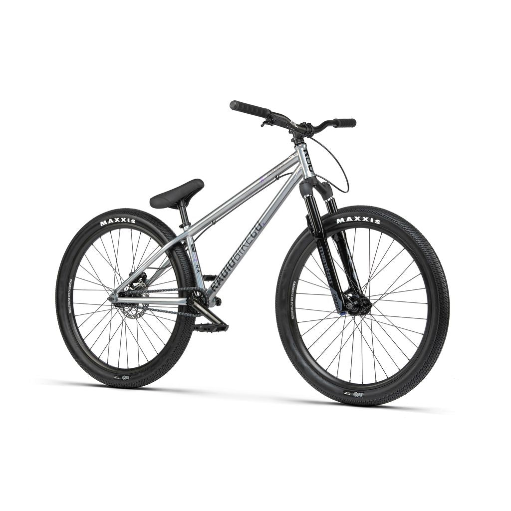 The Radio 26 Inch Asura Pro Bike, featuring a silver dirt jump frame, thick black Maxxis tires, a black saddle, and front and rear hydraulic disc brakes, is shown on a white background.