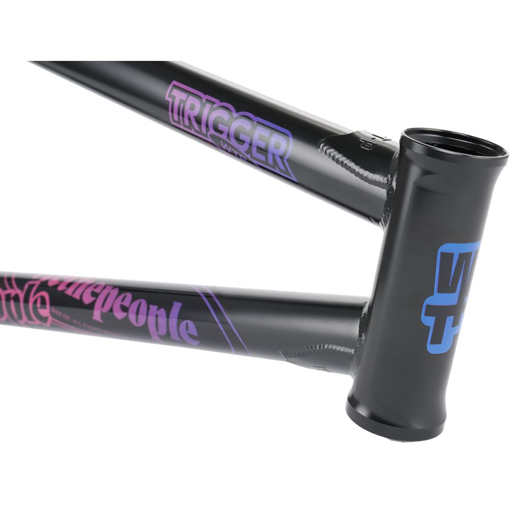 Close-up of a black Wethepeople Trigger Frame adorned with "TRIGGER" and other purple and blue designs, featuring adaptive geometry for a precision fit.