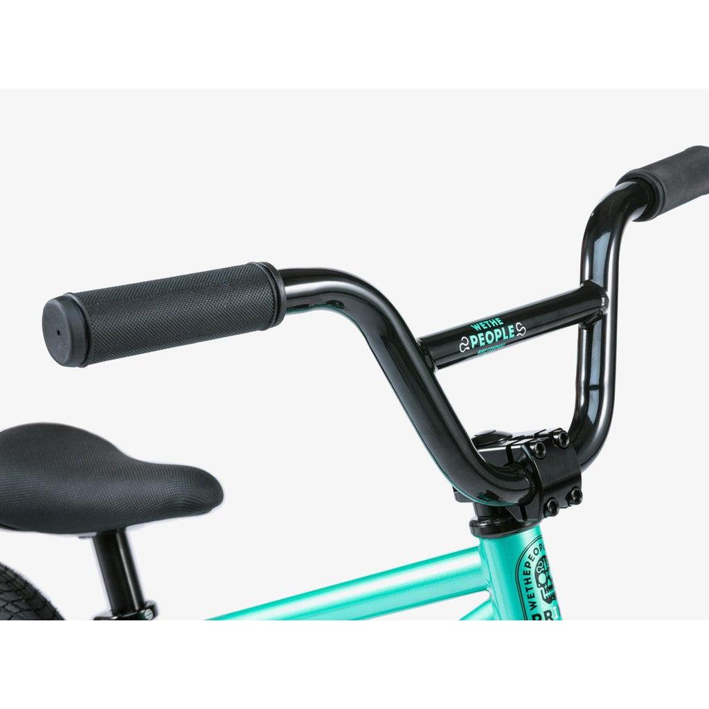 A close-up of the Wethepeople Prime Balance BMX Bike's handlebars showcases black grips and a turquoise frame, highlighting its sleek design.