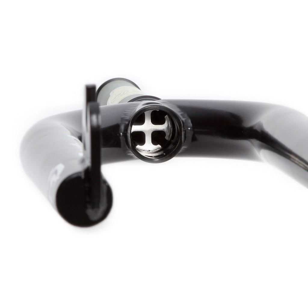 Close-up of a black bicycle handlebar end with a reflective, cross-shaped interior design, perfect for those who love the rugged durability of S&M Widemouth 20 Inch Forks.