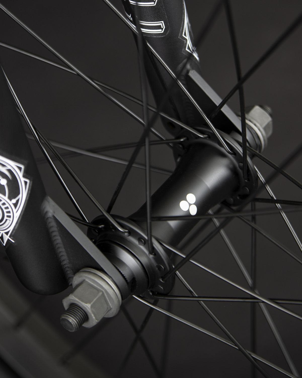 Close-up of the wheel hub with spokes and bolts on the Fly Bikes Neutron 20 Inch Bike, featuring a small white logo.