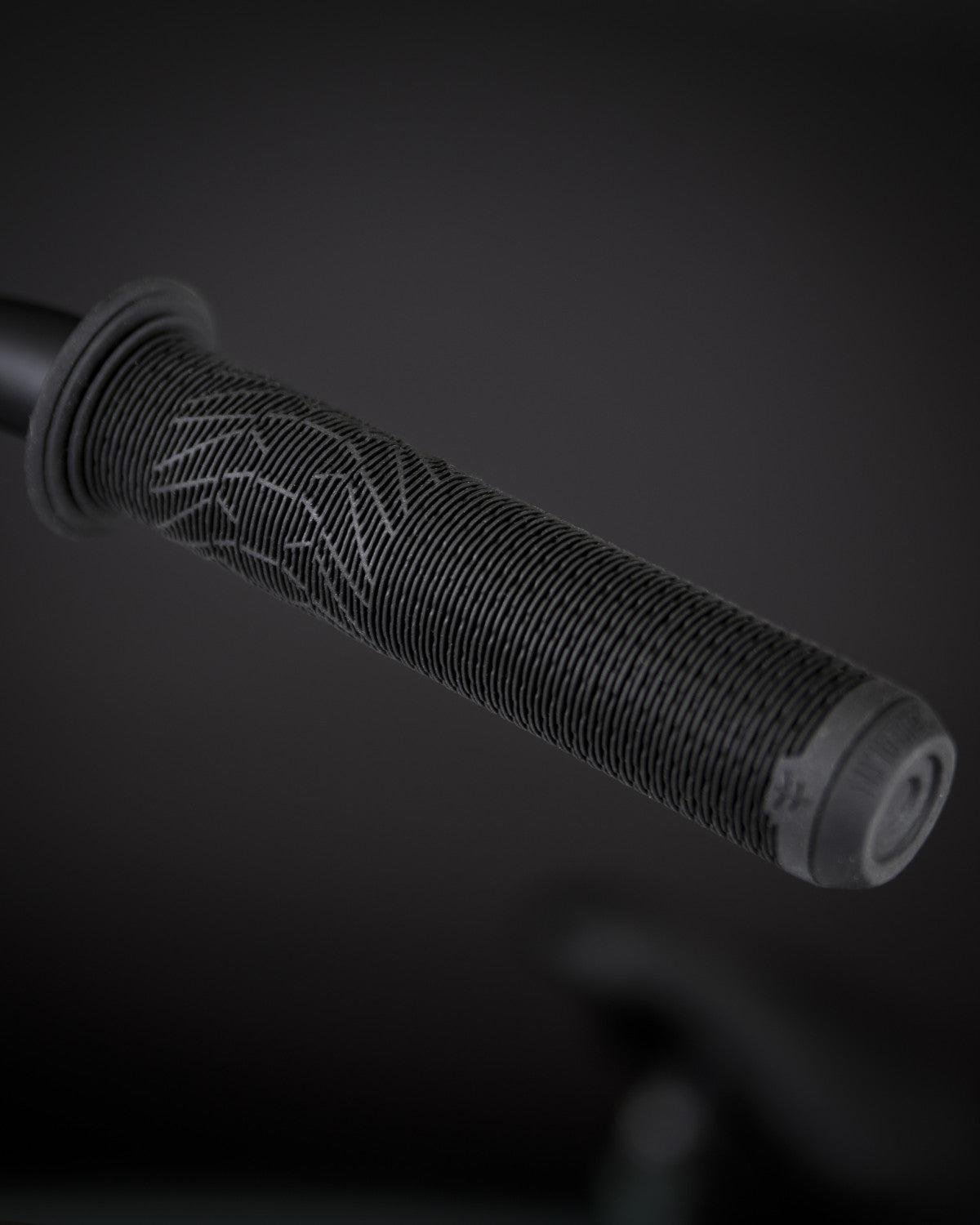 Close-up of the handlebar grip on a Fly Bikes Neutron 20 Inch Bike, showcasing the textured surface and subtle pattern against a dark background.