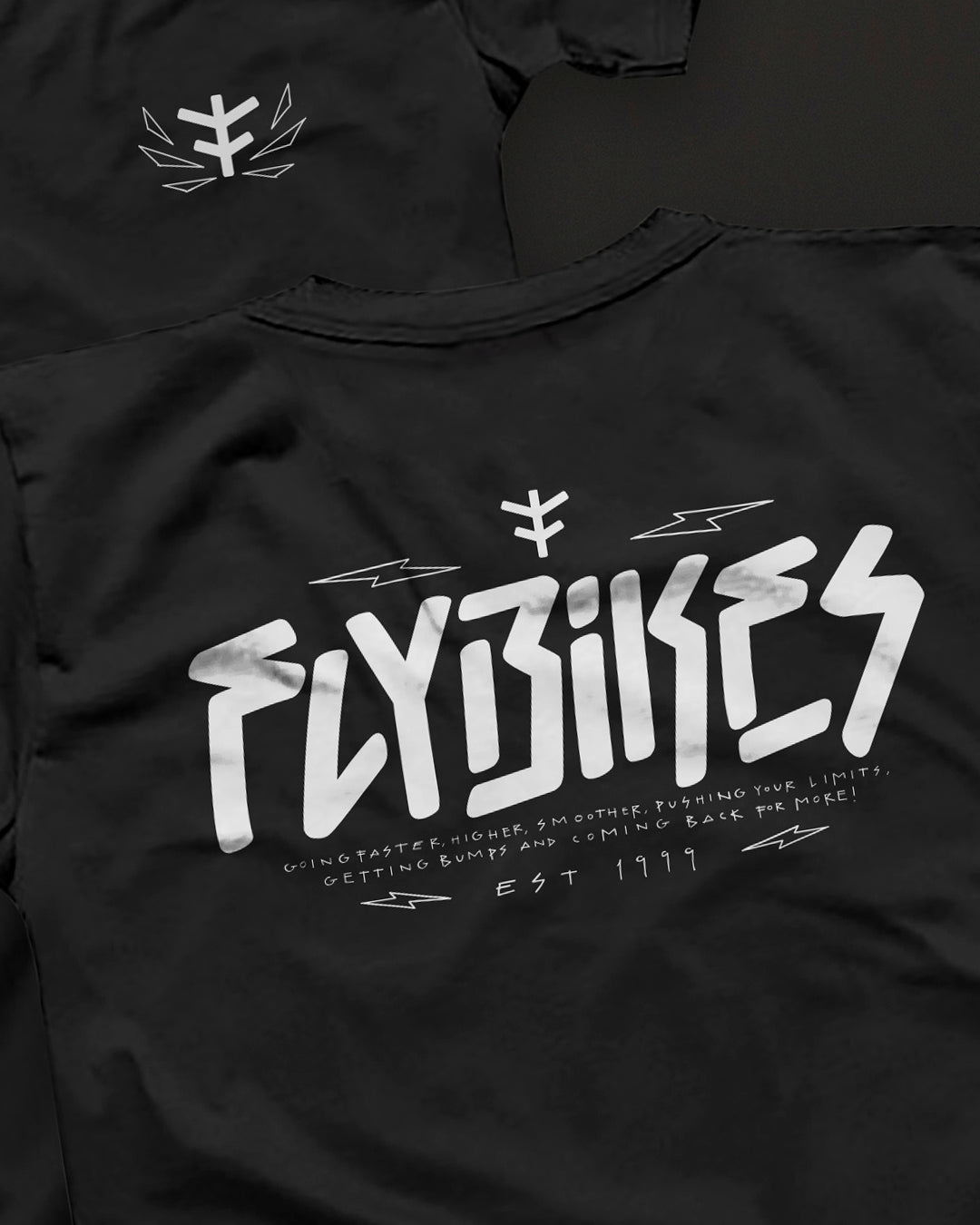 The Fly Bikes Faster T-Shirt is a black organic cotton tee with a white, stylized "Flybikes" logo and text featuring abstract design elements. Established in 1999, this GOTS certified garment promotes sustainable clothing values.