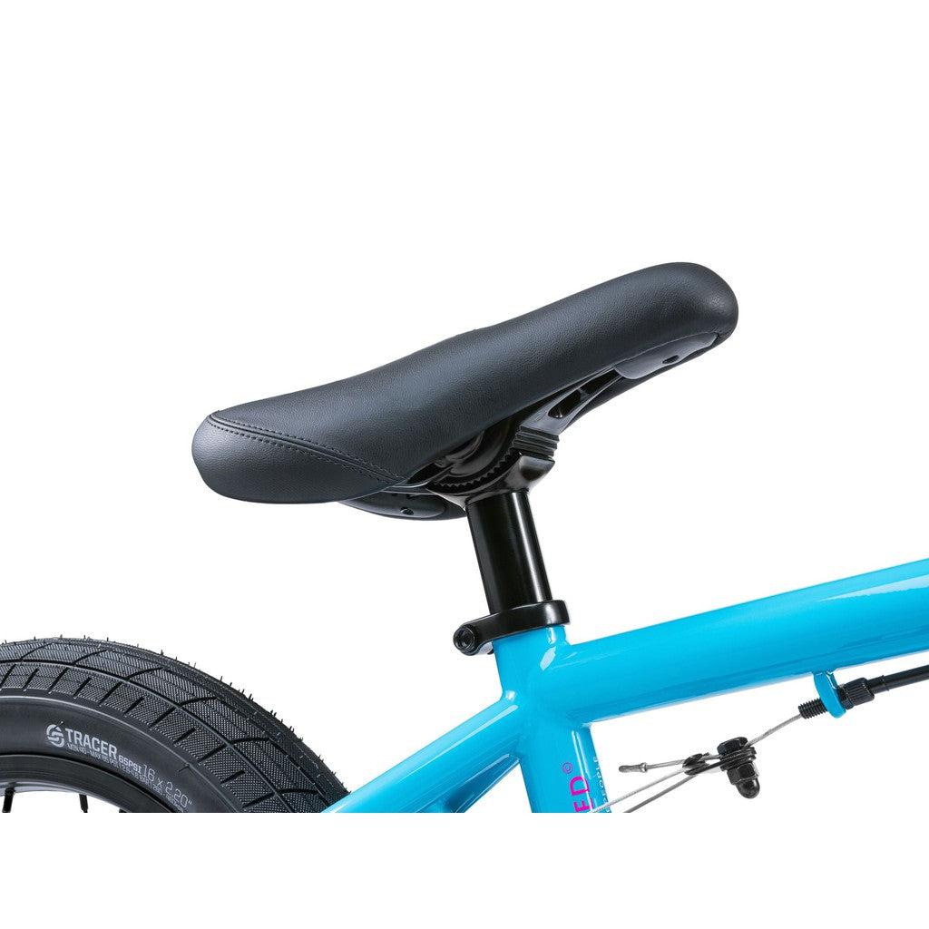 Close-up of the sleek black bicycle seat on a vibrant blue frame, part of the rear wheel visible — an ideal snapshot of the Wethepeople Seed 16 Inch Bike.