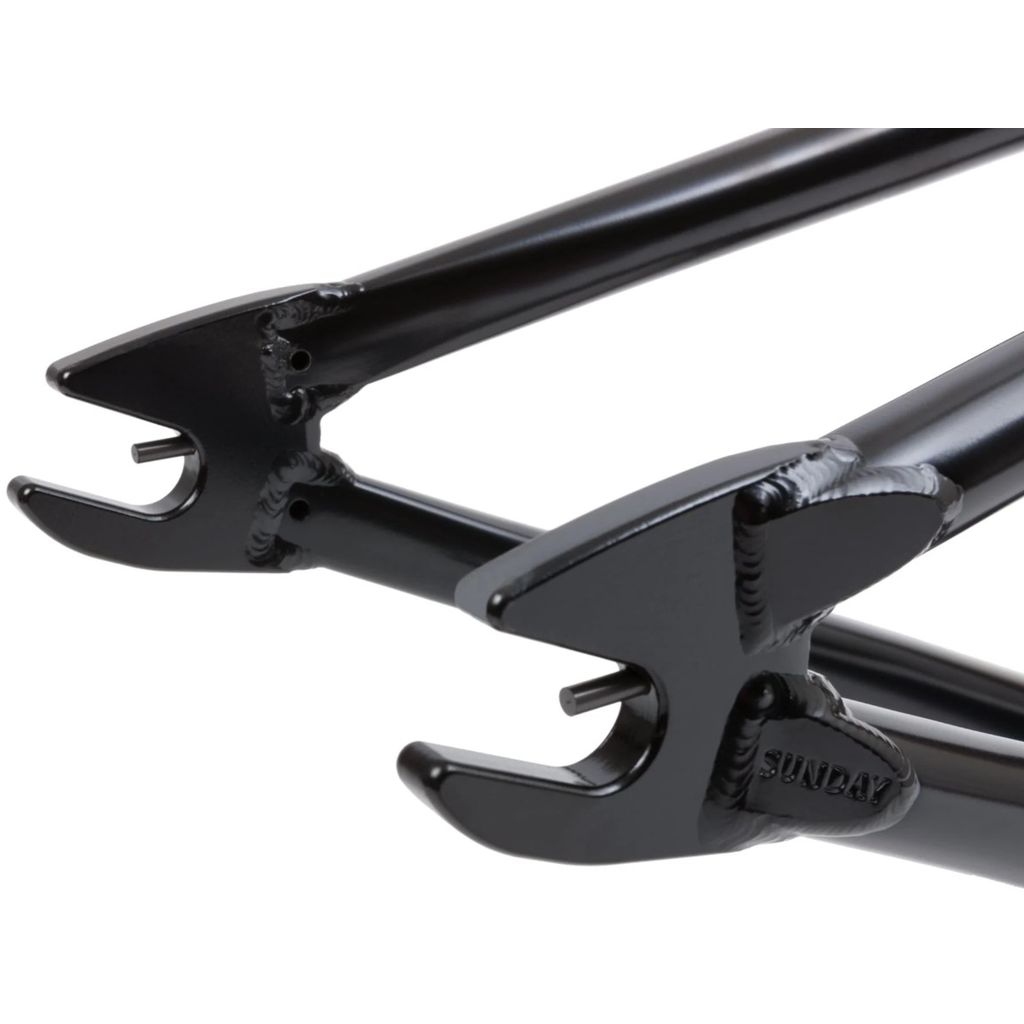 Close-up view of black metal bicycle dropout brackets with the word "Sunday" embossed on the edge, featured on the lightweight and strong Sunday Soundwave V3 Frame.