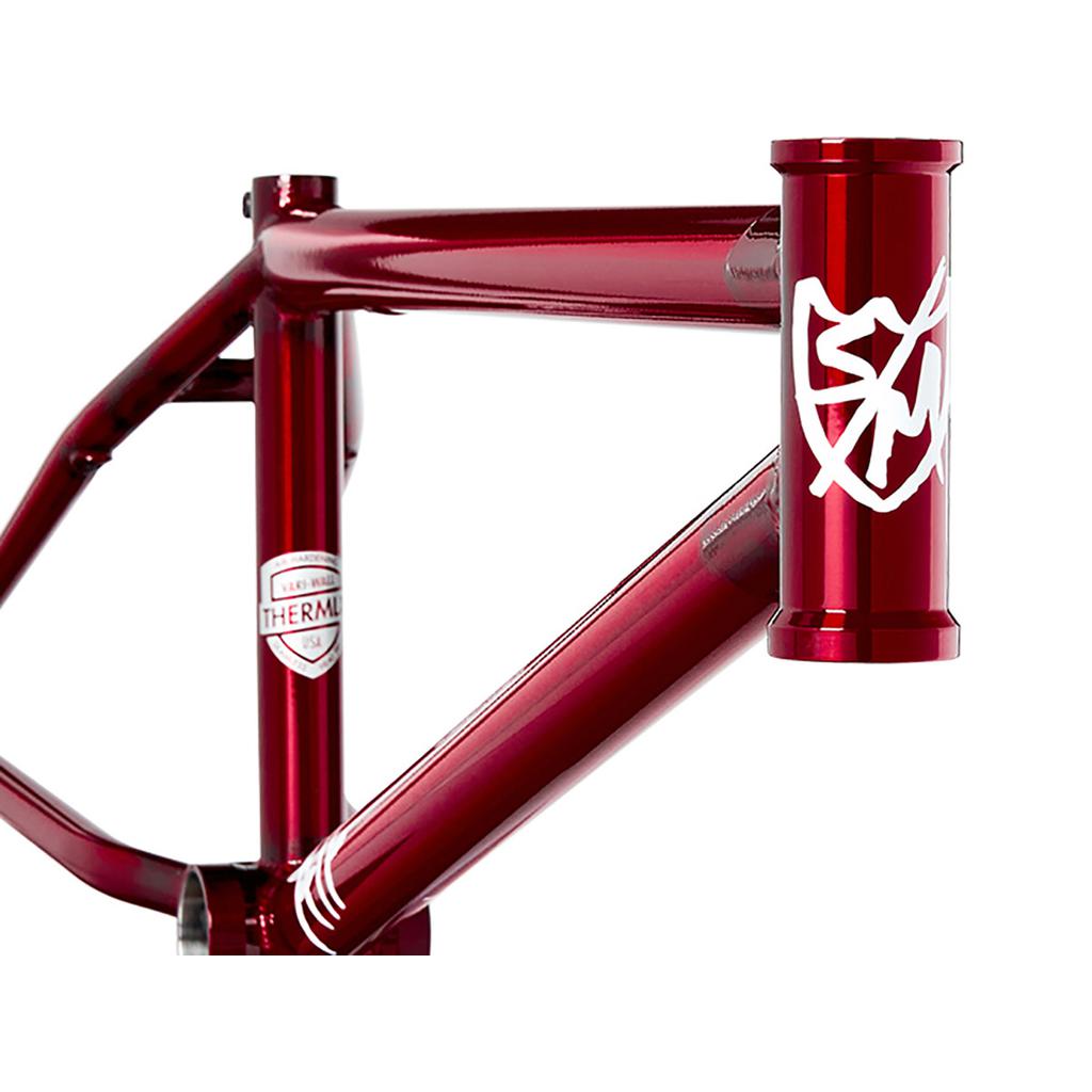 Close-up of the shiny red S&M ATF 20 Inch BMX frame, featuring a white emblem on the front tube and "Thermal" label on the side, highlighting its robust chromoly construction.