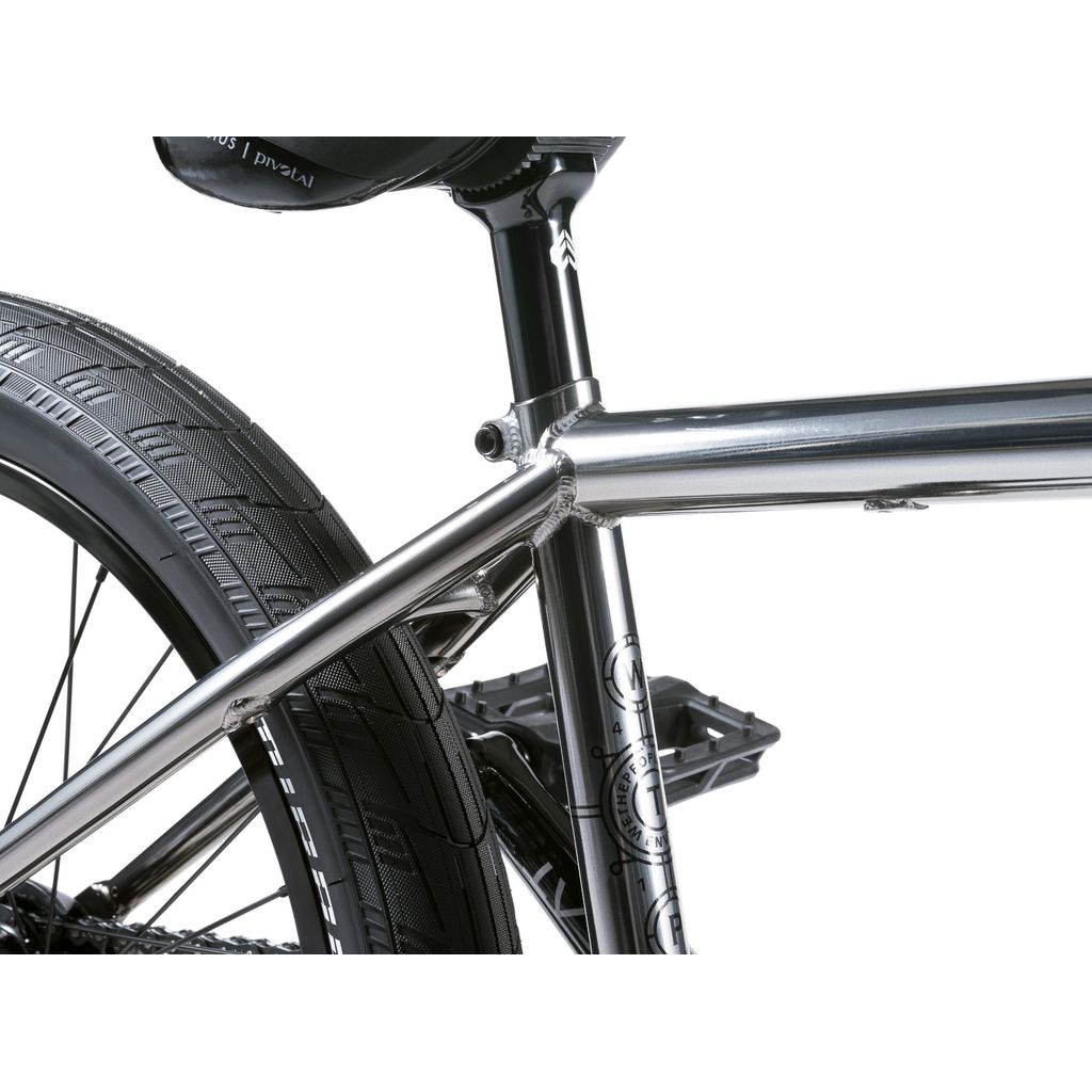 Close-up of the Wethepeople Envy 20 Inch BMX Bike's silver frame, highlighting its chromoly construction, visible welds, tread on the rear wheel, and seat post in view.