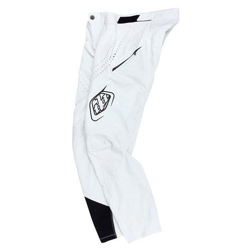 The TLD 25.1 Sprint Pant (Youth) in Chalk features black details and a logo on the thigh. Designed for ultimate performance, these race pants offer comfort and style with durable materials, a button closure, and ventilation holes.