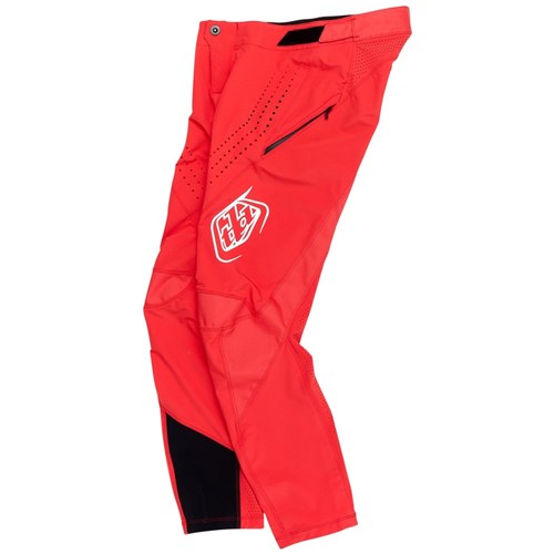 The TLD 25.1 Sprint Pant (Youth) in Fiery Red is a race-ready motocross pant crafted from durable materials, featuring thigh logos, ventilation perforations, a zippered pocket, and black accents near the cuffs.