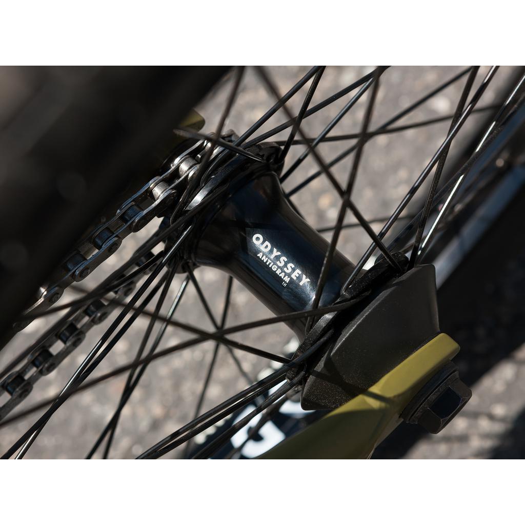 Close-up of a bicycle wheel hub branded "Odyssey," featuring spokes from the Sunday Wave Length 20 Inch (Gary Young) Bike, showcasing part of the gear mechanism for a high-end ride.