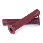 A pair of brand new Eclat Bruno Grips in maroon feature a textured surface, with one resting on top of the other. These grips seamlessly combine style and functionality, making them ideal for any rider.