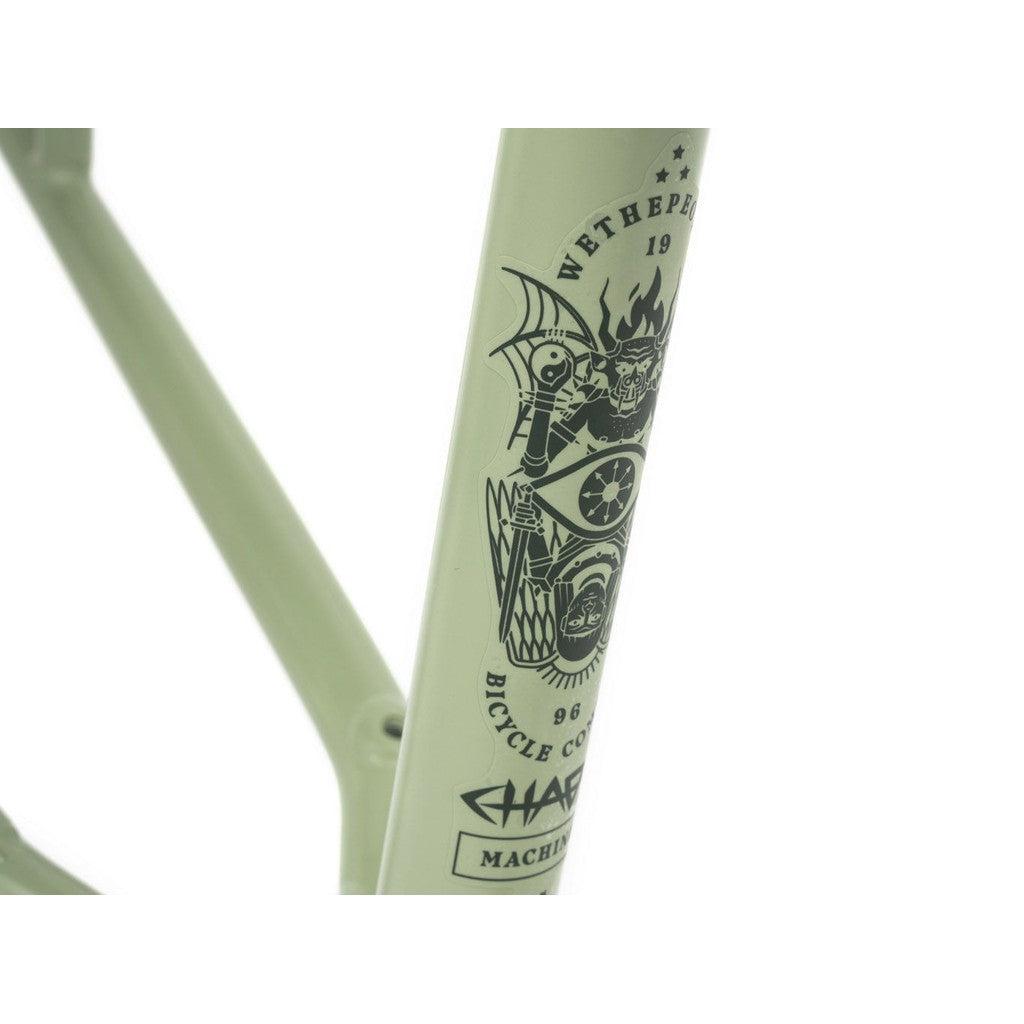 Close-up of the green 22-inch Wethepeople Chaos Machine Frame with black graphics, featuring "Wethepeople" and "Bicycle Co." text. This Tyson Jones-Peni signature model boasts a long and stable trail geometry for enhanced performance.