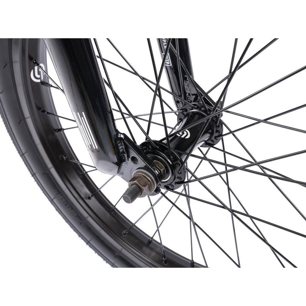 Close-up of the Wethepeople CRS FS 18 Inch BMX bike's wheel hub, spokes, and tire in black, ideal for freestyle adventures.