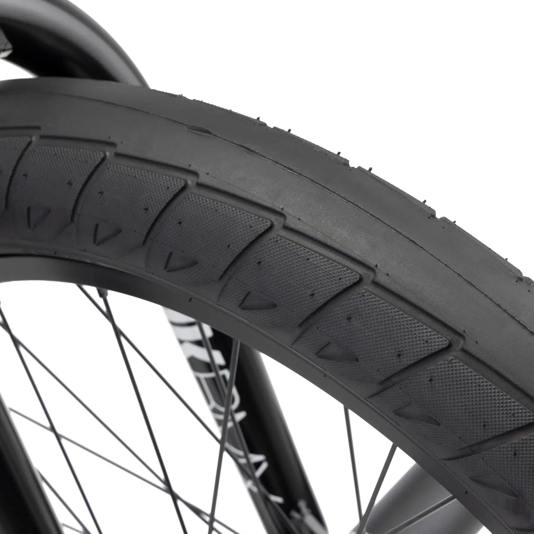 Close-up of the Kink Williams 20 Inch Bike's black tire featuring a textured tread pattern and spokes, perfect for any BMX bike enthusiast, inspired by the sleek designs favored by Nathan Williams.