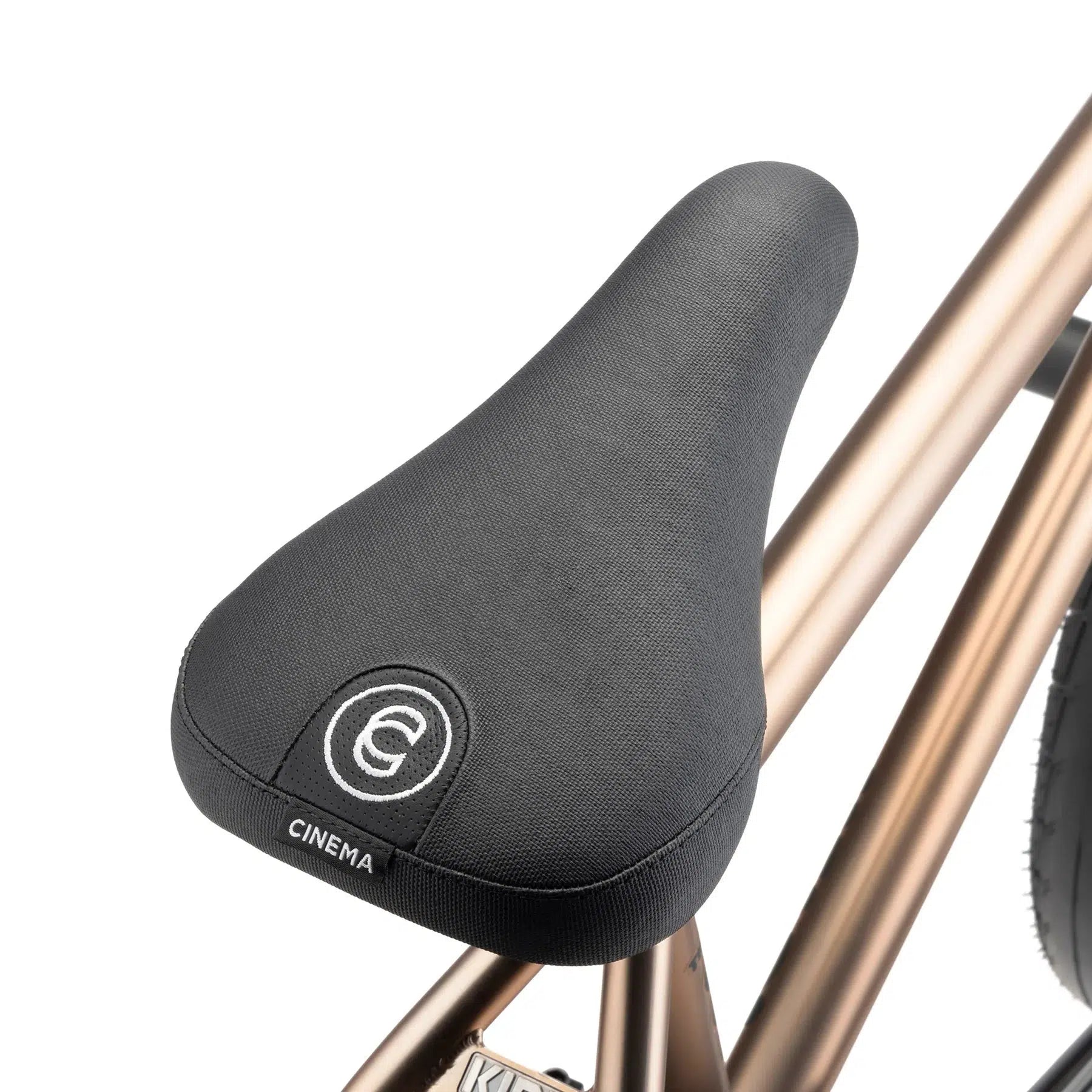 The Cinema-labeled black bike saddle is stylishly attached to the bronze-colored frame of a Kink Williams 20 Inch Bike, reminiscent of the sleek designs favored by riders like Nathan Williams.