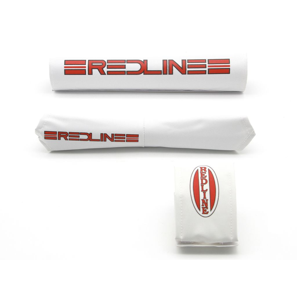 The Redline MX V-Bar Padset features white padding and a pad cover adorned with the iconic "Redline" logo in bold red text, evoking a classic old-school rig feel.