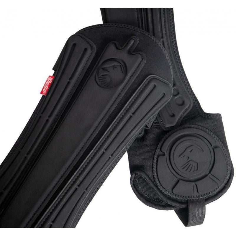 The Shadow Invisa-Lite Shin/Ankle Pad Combo for youth includes black protective gear with padded straps, molded details, an embossed logo, and a red tag. It features advanced 3D impact foam for superior ankle protection.