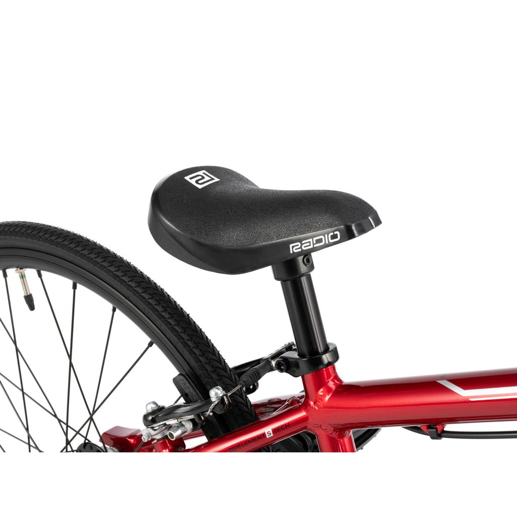 Close-up of a red bicycle seat with "Radio Cobalt Junior Bike" branding on a black saddle, attached to a metallic red BMX race bike frame and rear wheel.