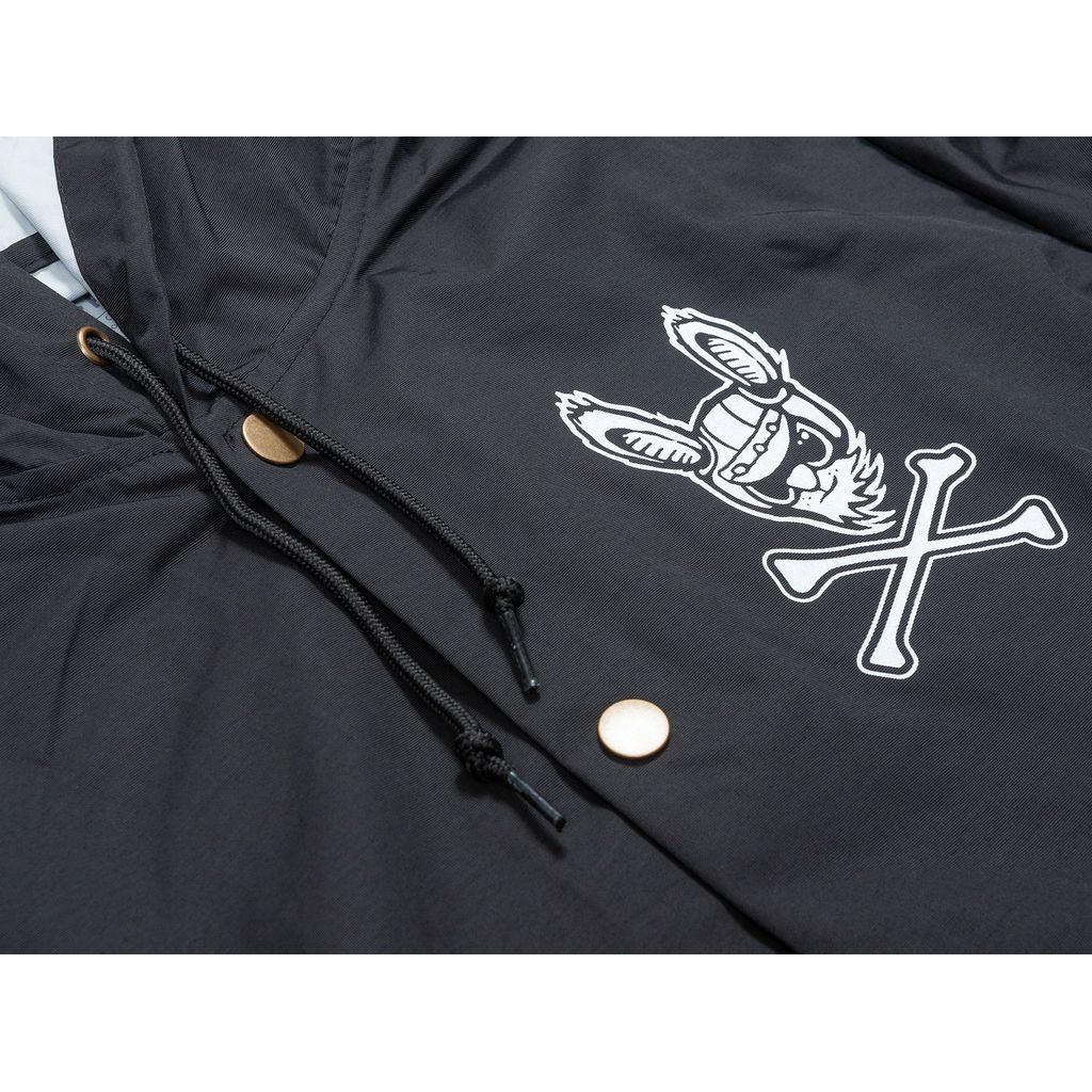 A close-up of a Fairdale Harerogers Windbreaker Jacket with a white graphic of a bunny wearing a helmet and crossed drumsticks on the chest, featuring drawstrings with gold-colored metal tips.