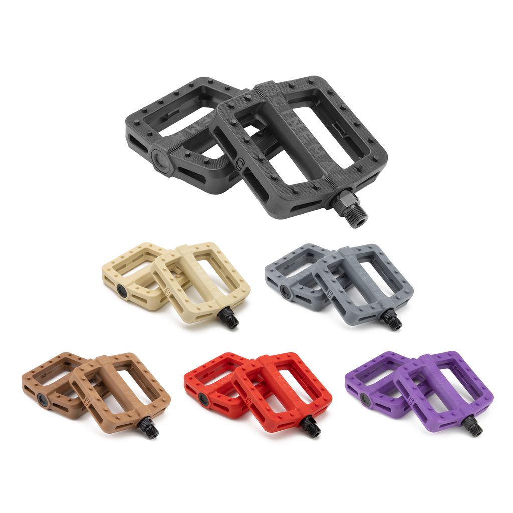 Bicycle pedals in a range of colors, such as black, beige, gray, brown, red, and purple Cinema Tilt Pedals featuring traction pins for enhanced grip and a zero offset design for efficient power transfer, are showcased against a white background.