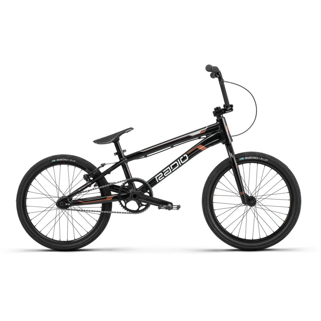 A black BMX bicycle, the Radio Xenon Pro Bike, with "Radio" branding on the frame, featuring a single gear, black tires, and a sleek, minimalist design. This race bike embodies performance and style.