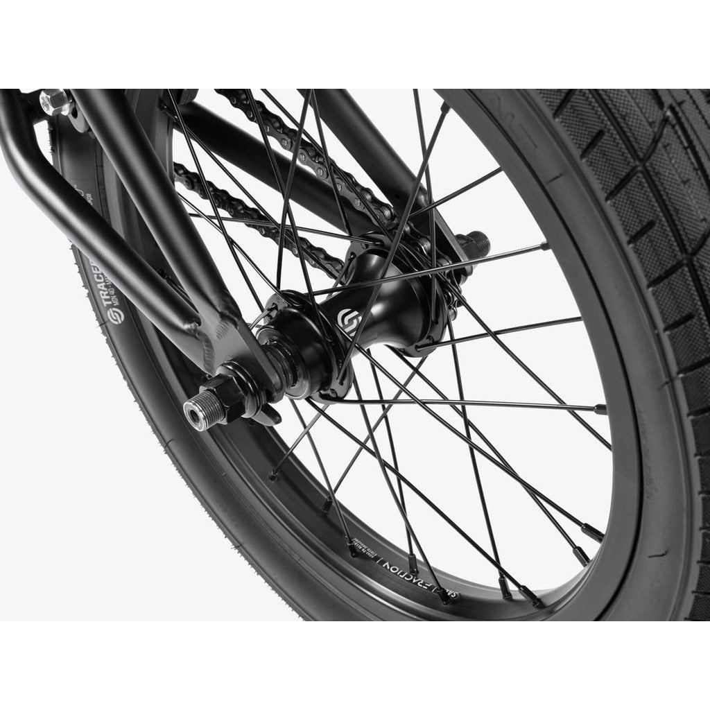 Close-up of a black Wethepeople Seed 16 Inch Bike wheel, showcasing the hub, spokes, and tire tread against a white background.