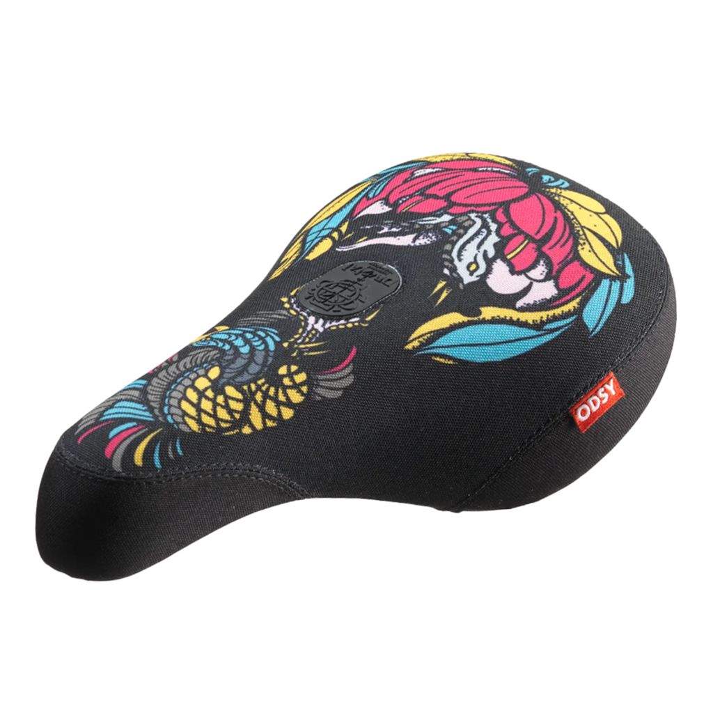 A black Odyssey IG Hot Seat bicycle seat features colorful floral and bird designs with a red label displaying white text "ODSY" on the side.