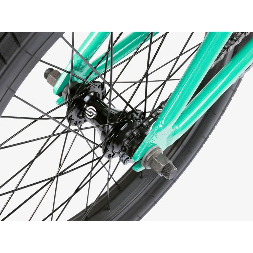 Close-up of the Wethepeople CRS FS 18 Inch BMX Bike with a turquoise frame, black hub and spokes, highlighting its freestyle style and sleek salt rotor setup.