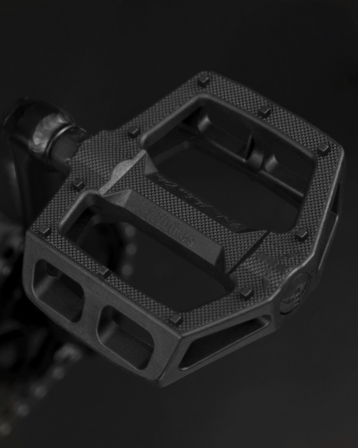 Close-up of a black bicycle pedal with a textured surface and sturdy, angular design, perfectly complementing the Fly Bikes Electron 20 Inch Bike equipped with a durable CrMo Crankset.