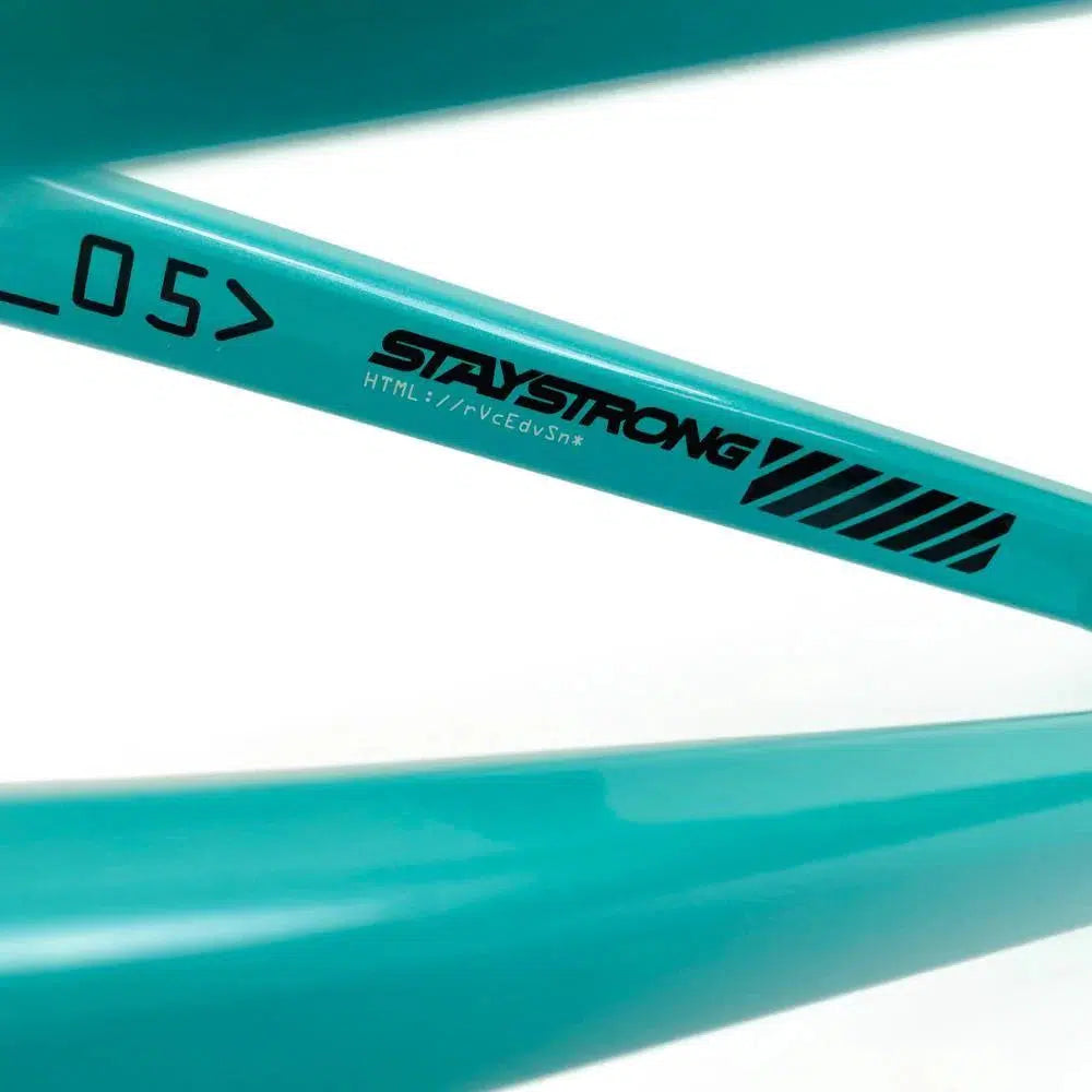 Close-up view of a teal aluminium race frame featuring the text "Staystrong V5 Disc Junior Frame" along with some other small alphanumeric characters and designs.