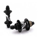 The Pride Control Expert 28H Hubset, with its sleek black and silver BMX racing hubs crafted from CNC machined aluminum, is elegantly displayed with branding details—one hub facing forward and the other tilted backward against a pristine white background.