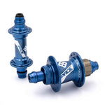 The Pride Control Expert 28H hubset, consisting of two blue BMX racing hubs made from CNC machined aluminum with flanges and branded decals, is displayed on a white background. One hub stands upright while the other lies flat, both designed to be disc brake ready for enhanced performance.