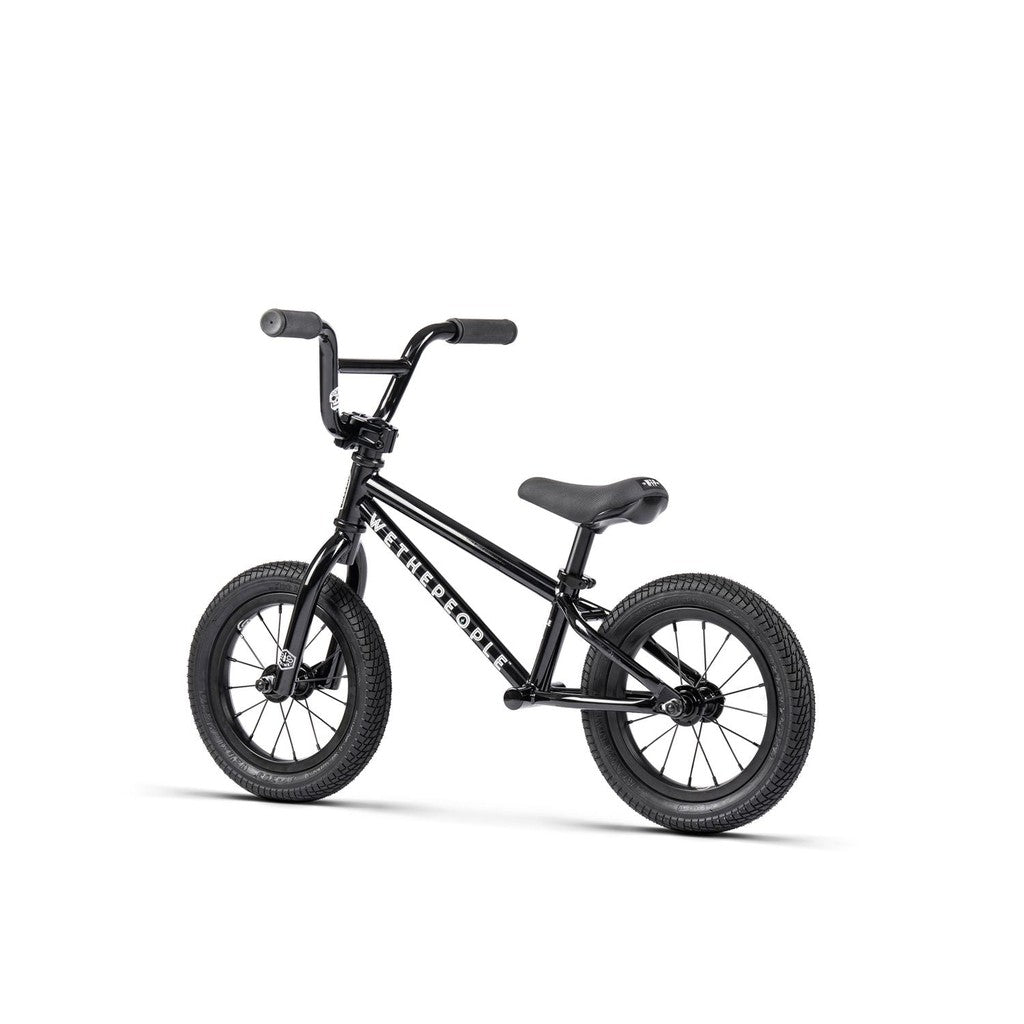 The Wethepeople Prime Balance BMX Bike is a small black balance bike with thick tires and a labeled frame, expertly designed for young children seeking their prime riding experience.