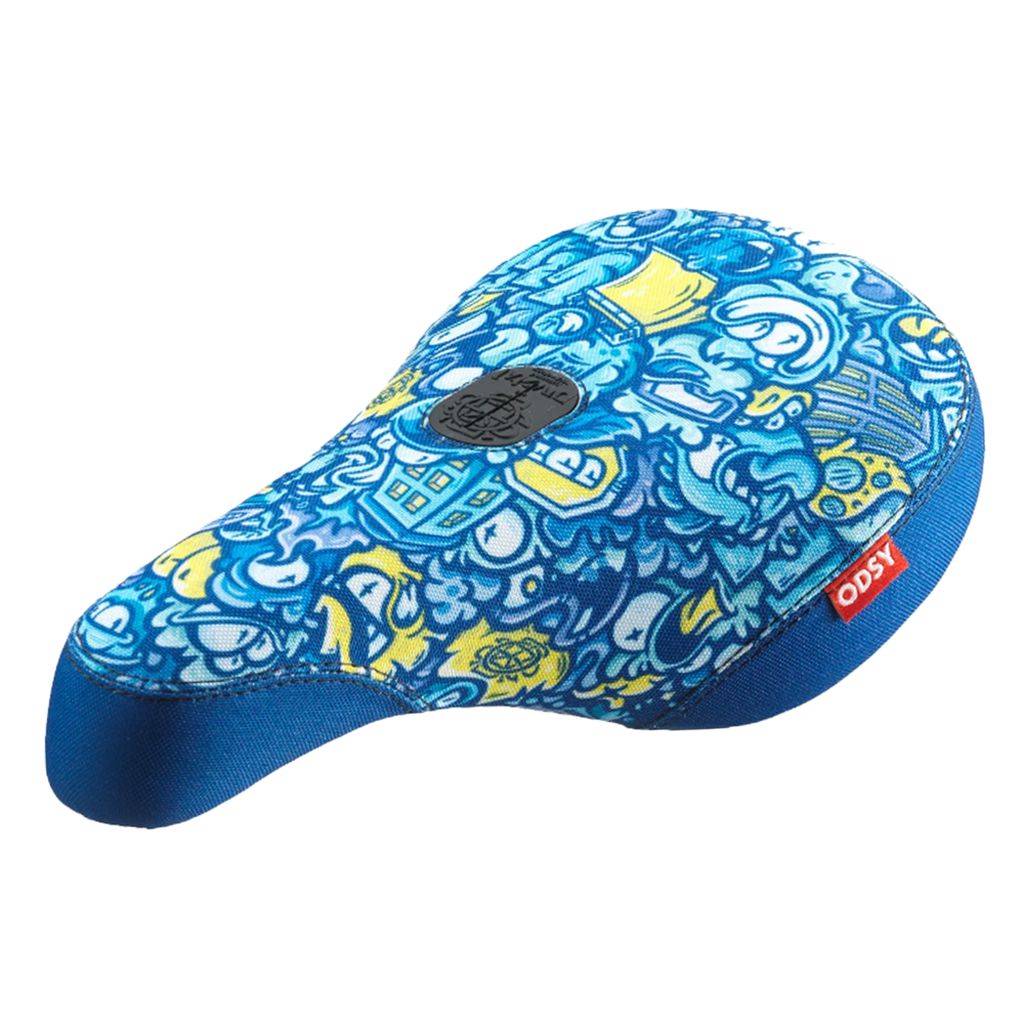 The Odyssey IG Hot Seat, a bike seat featuring a blue and yellow color scheme with a vibrant abstract design and a small red tag labeled "ODSY," adds an eccentric touch.