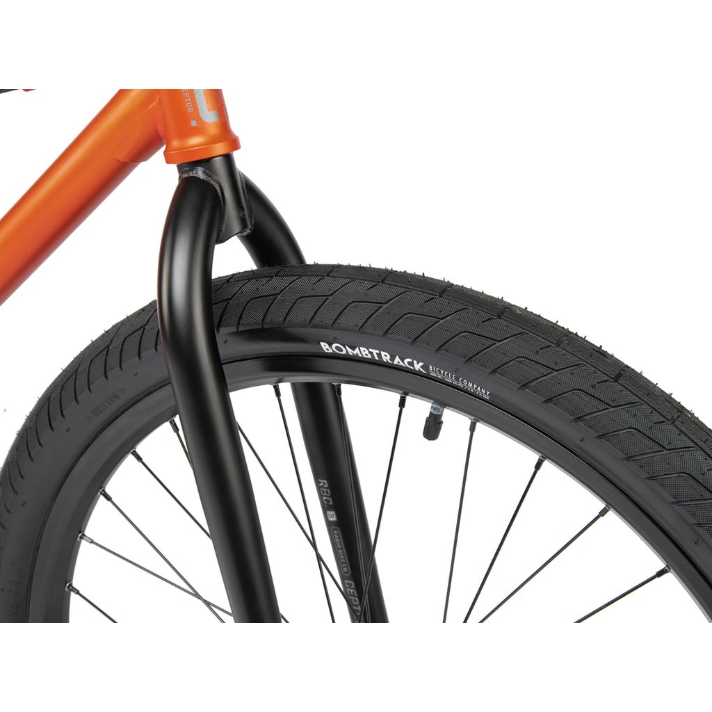 Close-up of a black front bicycle wheel with a Radio 26 Inch Ceptor Bike tire and sealed bearings, attached to an orange BMX bike frame.