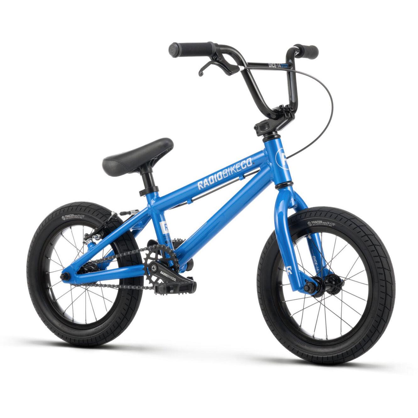 A blue children's BMX bike, the Radio Dice 18 Inch Bike, with black handlebars, seat, and Salt Tracer Tyres stands on a white background. The bike is labeled "RADIOBIKECO" on the frame.