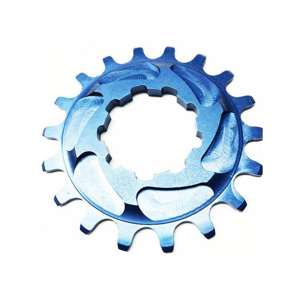 The Rennen Alloy Cog is a circular blue gear with a single speed-specific tooth profile, made from 7075-T6 Aluminium and featuring a decorative design, likely used for mechanical applications. It is displayed on a pristine white background.