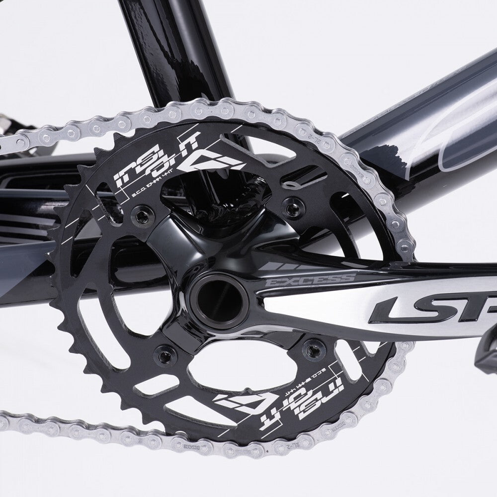 Close-up of a bicycle crankset and chain. The black and silver crank arms and chainrings are part of the drive system on a Chase Element Pro XXL Bike, showcasing detailed mechanical components.