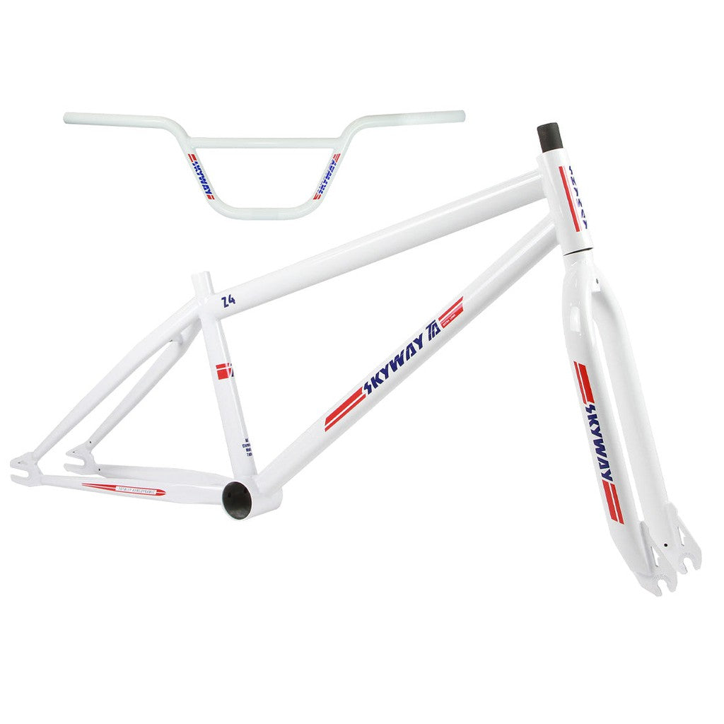 A white BMX bike frame and handlebars with blue and red decals, branded “Skyway TA 24 Replica Frame / Fork / Bars Kit,” are displayed against a white background.