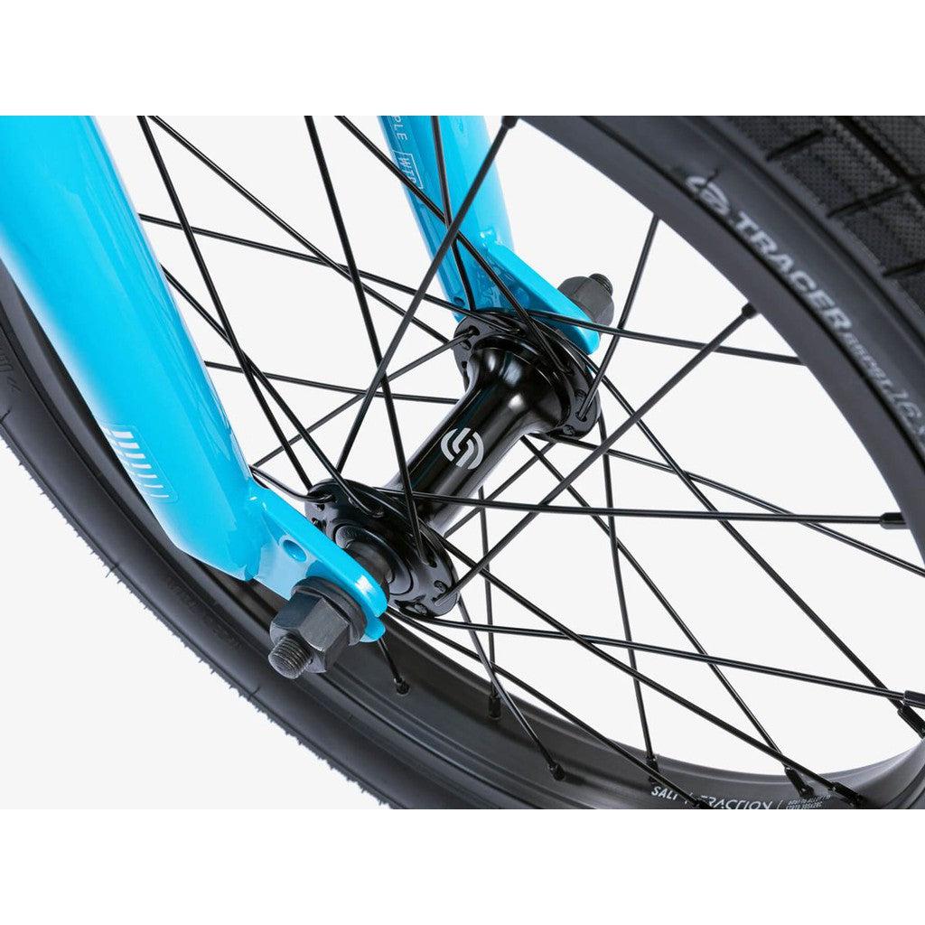 Close-up view of the Wethepeople Seed 16 Inch Bike's BMX shredder wheel featuring a black hub and spokes, mounted on a blue fork.