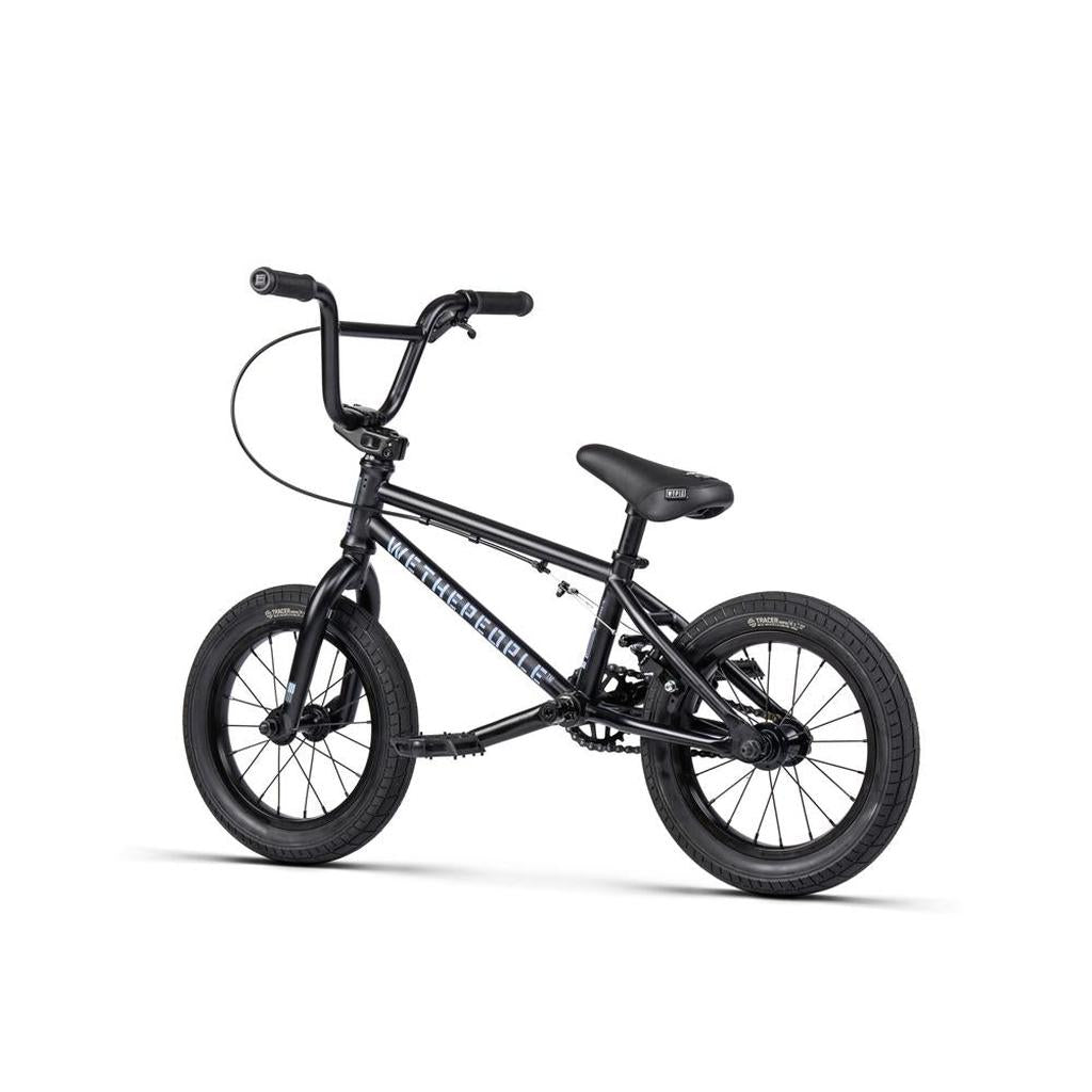 A black Wethepeople Riot 14 Inch BMX bike is featured on a white background, showcasing its sleek frame, thick tires, Chromoly cranks, and angled handlebars.