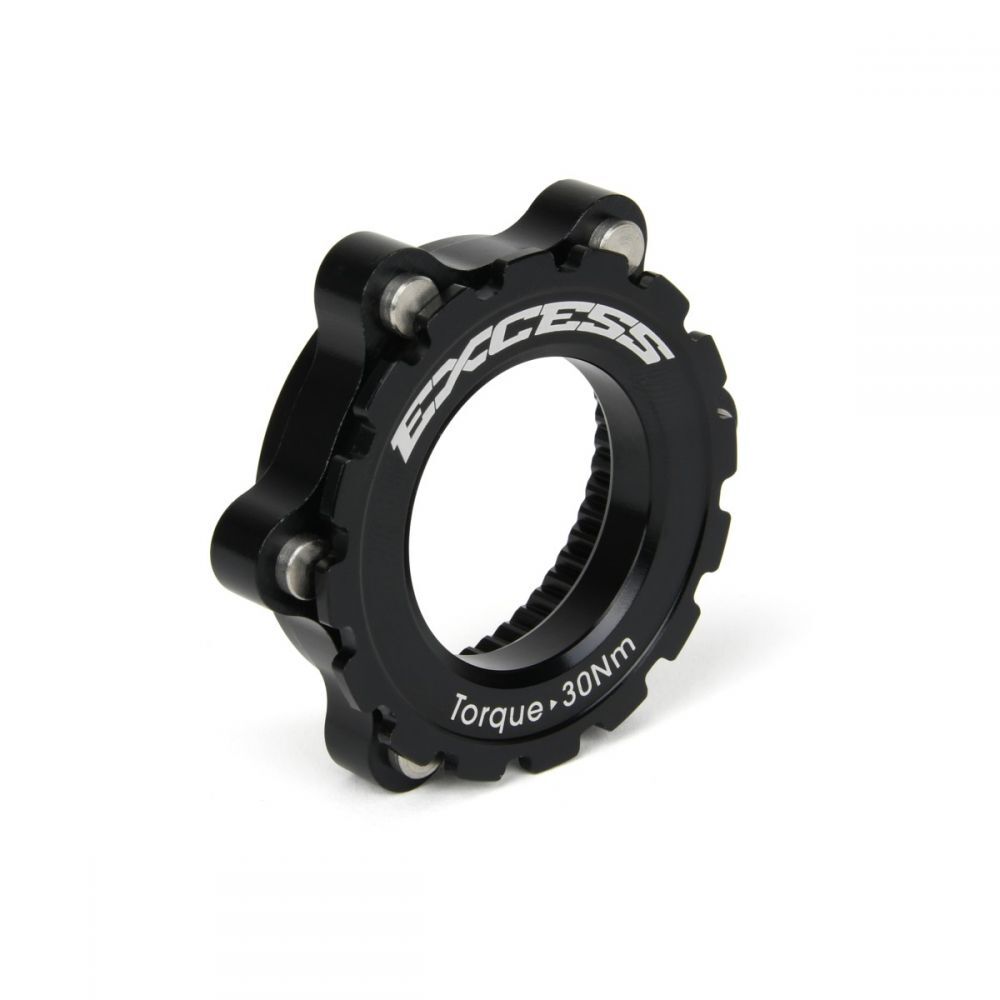 Close-up of a black bicycle sprocket lockring displaying the word "EXCESS" and "Torque - 30Nm" beneath. Adjacent to it, the Excess Centerlock ISO Adapter Kit is snugly fitted.