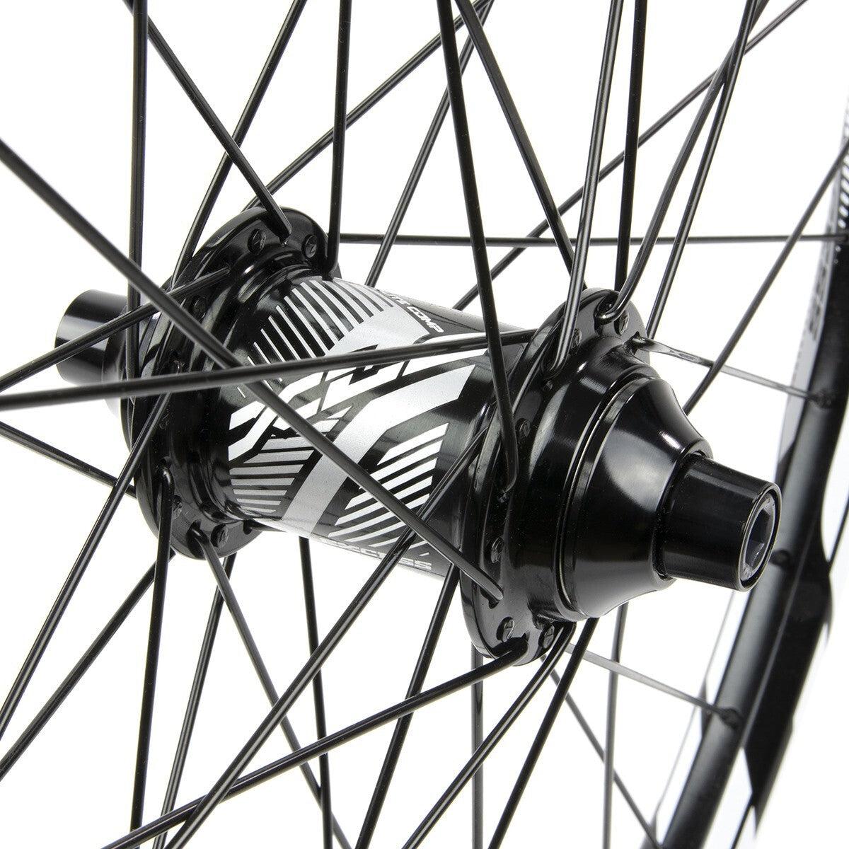 Close-up of the Excess XLC-1 Alloy Wheel Set hub with black spokes radiating outward. The hub, designed for disc brake conversion, features a detailed striped design.