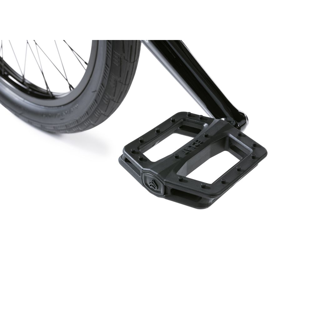 Close-up of a black bicycle pedal and rear tire part, highlighting the textured surface and robust metal frame of the Wethepeople Envy 20 Inch BMX Bike with durable chromoly construction.