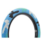 The DRS Arrow FS 20 Inch Tyre features a blue camo pattern with patches of white, green, and black, set against a white background.