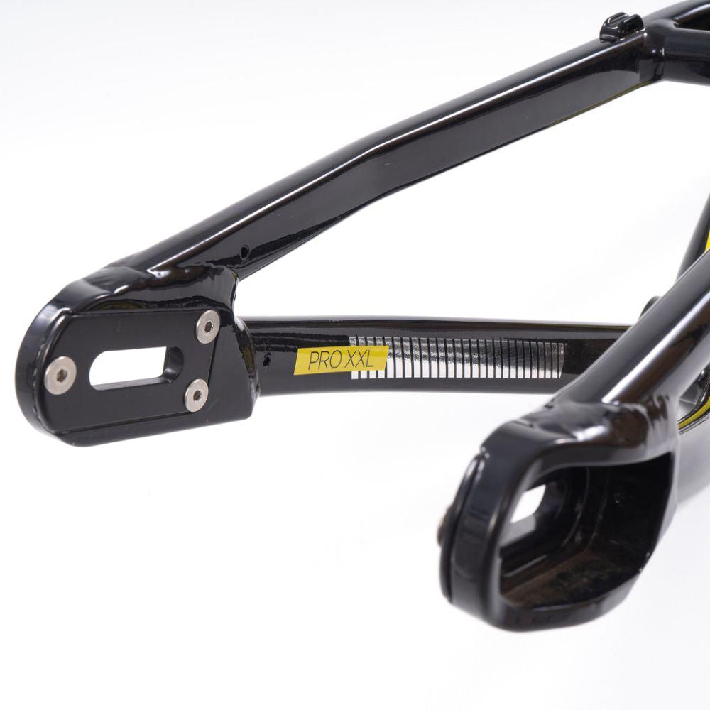 Close-up of a black BMX bike frame labeled "PRO XXL" on a yellow sticker, showcasing metallic components and bolt holes. This expert cruiser, the Staystrong V4 Frame Expert XL Cruiser, offers superior performance inspired by its advanced design.