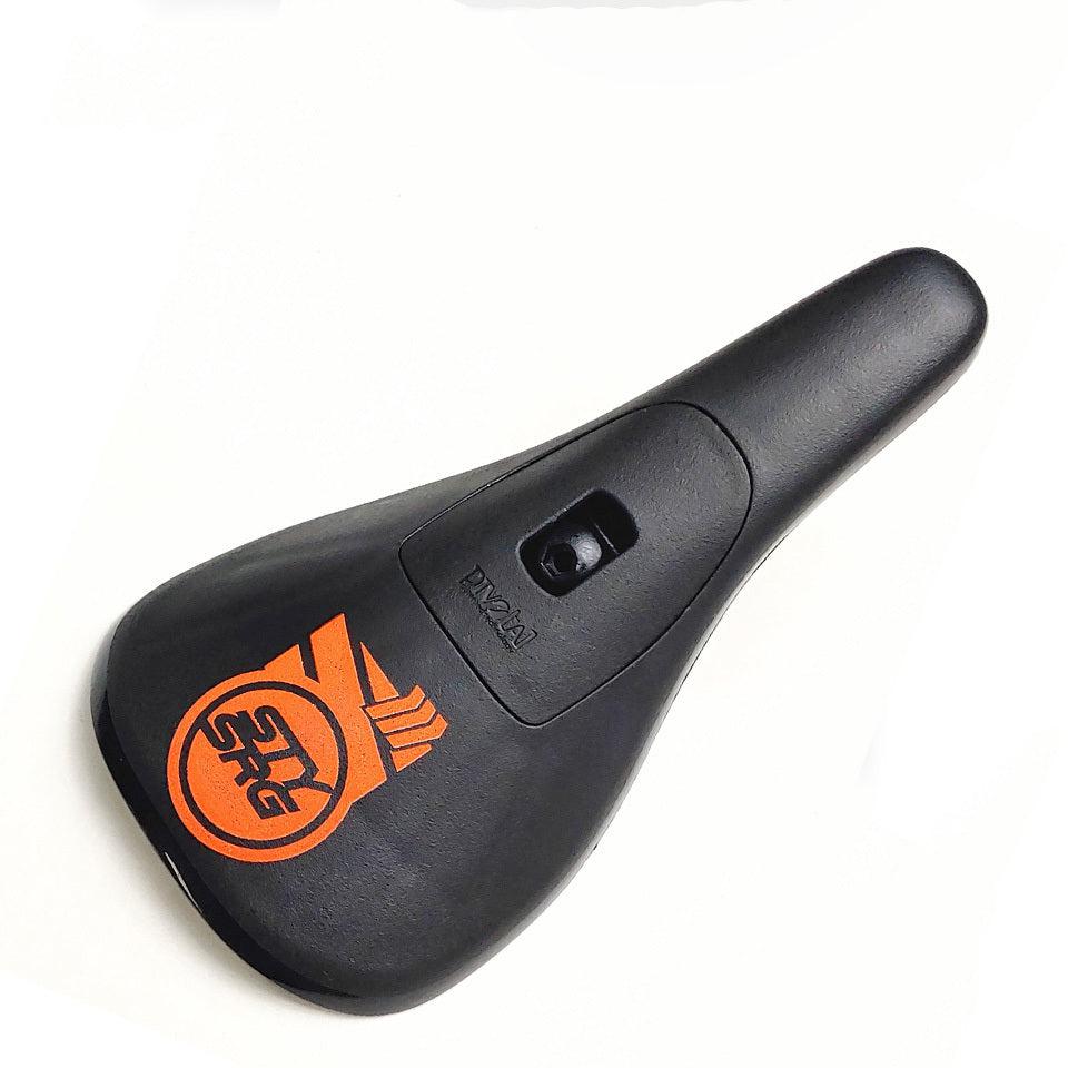 Stay Strong Fast Chevron Plastic Pivotal Seat in black with an orange chevron pattern and a central cutout, captured from above on a white background. Ideal for your race bike and designed to support you on every ride.